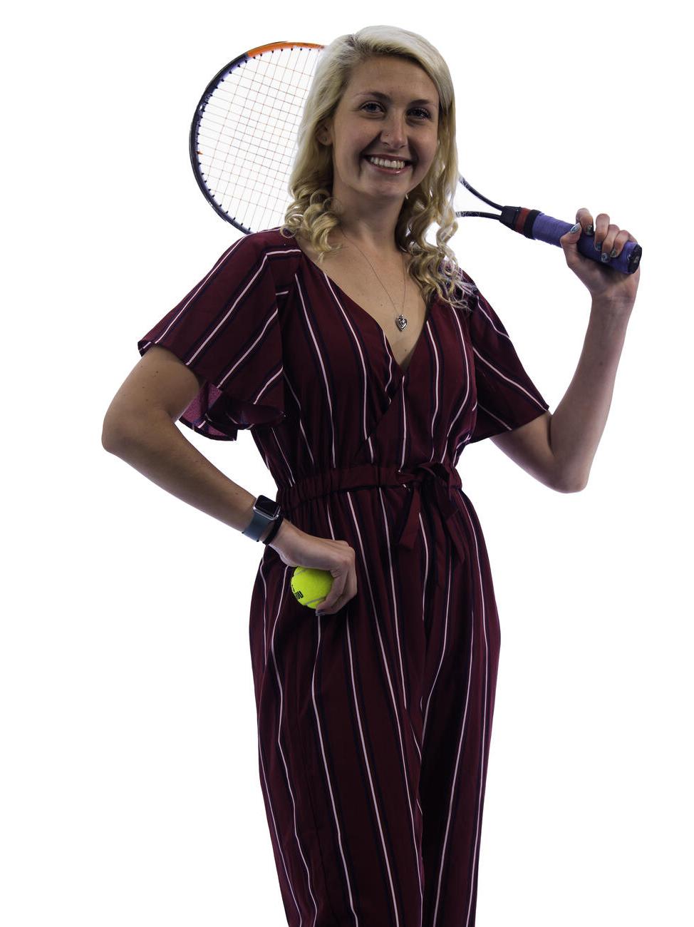 卡西迪·赖特一手拿着网球，肩上扛着网球拍.