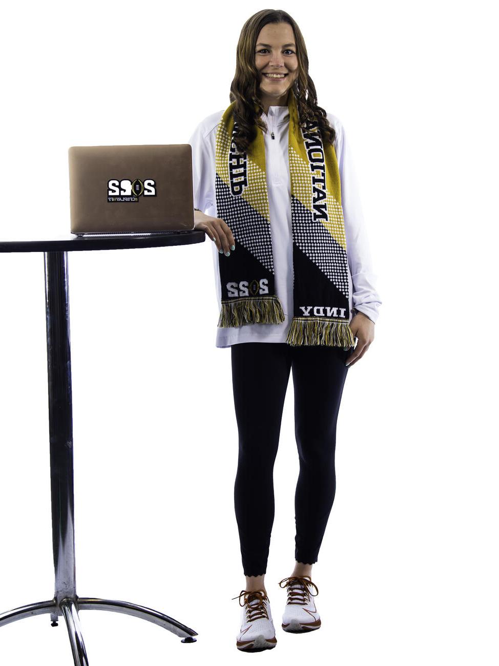 Kaylen Buschhorn poses by a table with a laptop.
