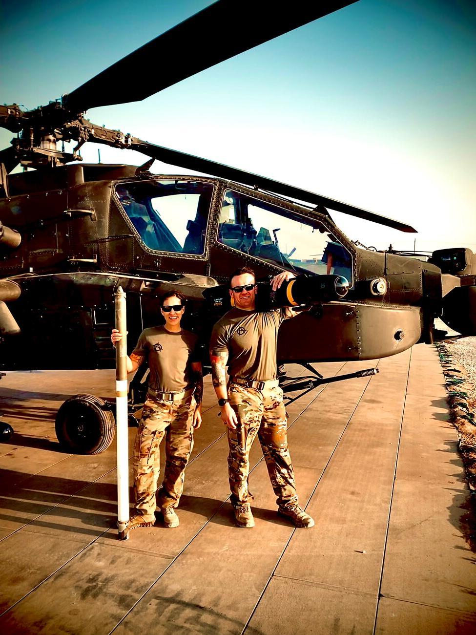 在叙利亚，尼克和妻子梅根·朱斯蒂站在一架直升机前.