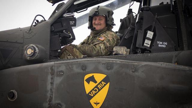 Alum Zach Nibbelink looks at the camera while sitting in an Apache helicopter cockpit.